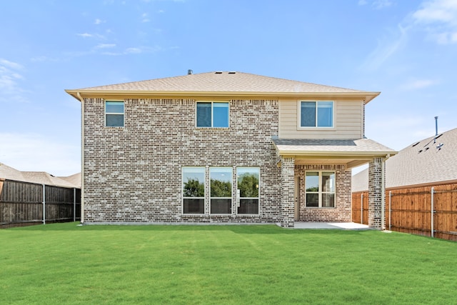 rear view of house featuring a lawn and a patio