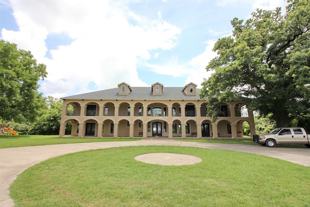 view of front facade featuring a front yard and a balcony