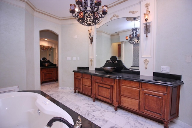 full bathroom featuring ornamental molding, a whirlpool tub, a notable chandelier, marble finish floor, and vanity