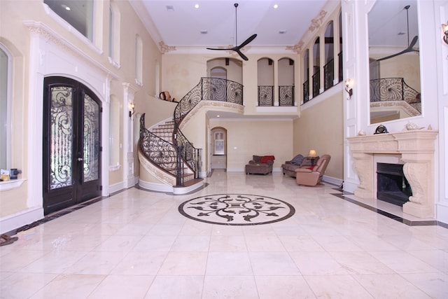 tiled foyer entrance featuring a high ceiling, ceiling fan, and french doors