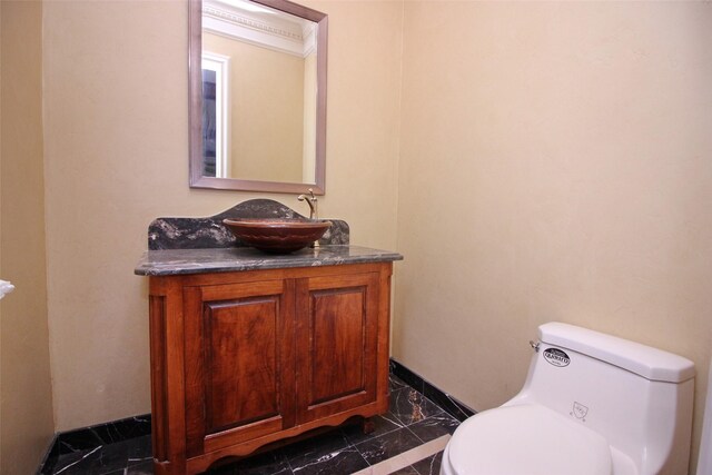 bathroom featuring marble finish floor, toilet, vanity, and baseboards