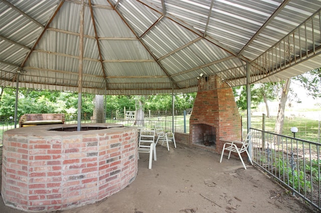 view of terrace featuring exterior fireplace and a gazebo