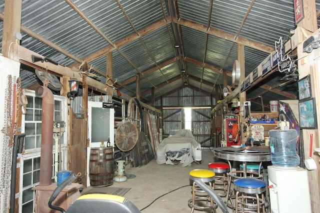 miscellaneous room with lofted ceiling, metal wall, and concrete flooring