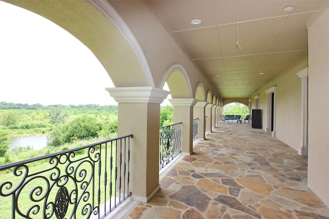 exterior space featuring a balcony and a water view