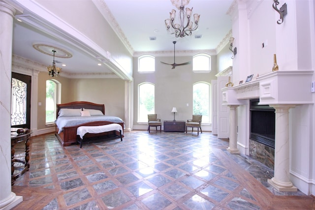 bedroom featuring a notable chandelier, crown molding, a towering ceiling, and a premium fireplace