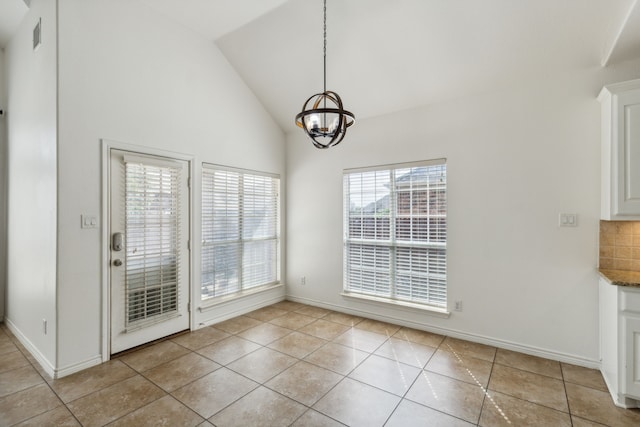 unfurnished dining area with light tile patterned flooring, high vaulted ceiling, and a notable chandelier