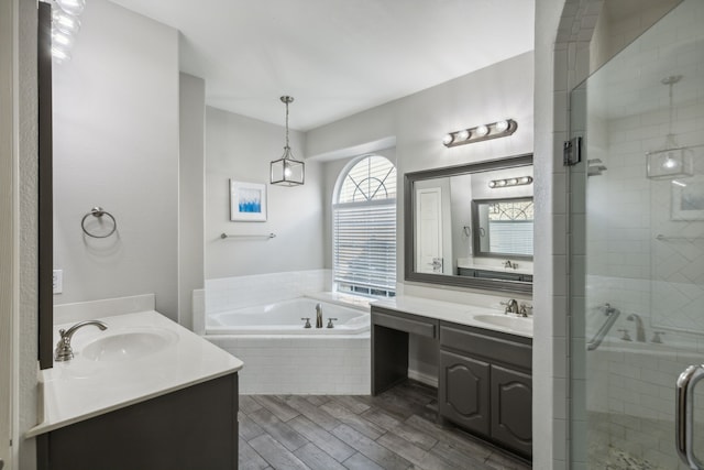 bathroom with hardwood / wood-style flooring, separate shower and tub, and vanity