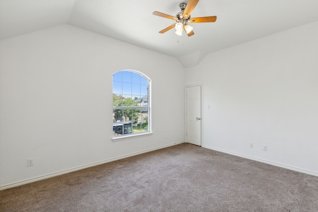 empty room with ceiling fan, carpet flooring, and vaulted ceiling