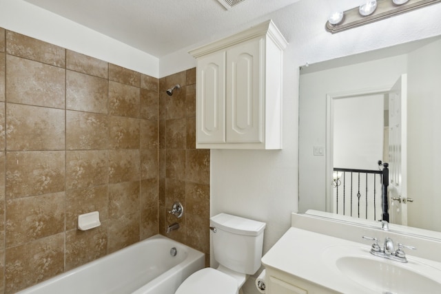 full bathroom with vanity, toilet, tiled shower / bath, and a textured ceiling