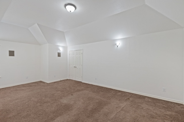 bonus room featuring vaulted ceiling and carpet