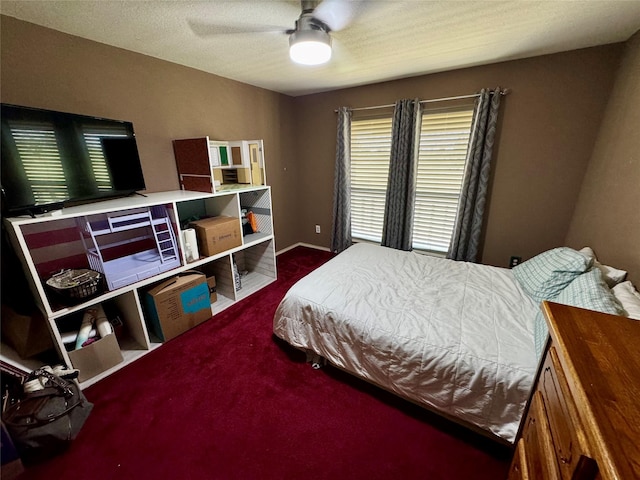 bedroom with a textured ceiling, dark carpet, and ceiling fan