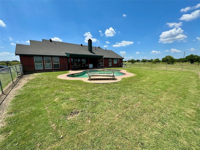 back of house with a fenced in pool, a yard, and a patio