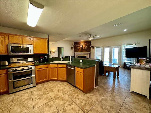 kitchen featuring kitchen peninsula, french doors, stainless steel appliances, and sink