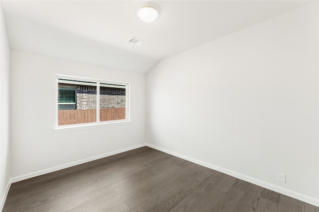 spare room with vaulted ceiling and dark hardwood / wood-style floors