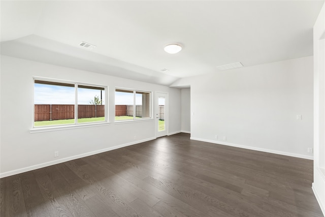 spare room with vaulted ceiling and dark hardwood / wood-style floors