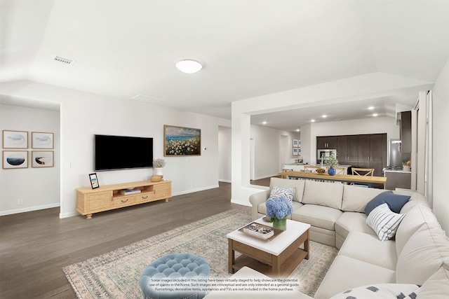 living room featuring vaulted ceiling and hardwood / wood-style flooring