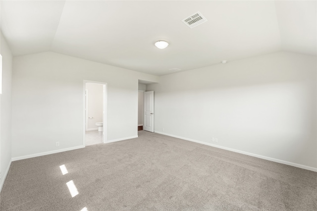 carpeted empty room with lofted ceiling