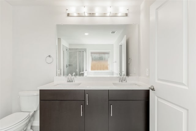 bathroom with an enclosed shower, vanity, and toilet