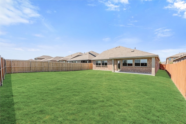 rear view of house featuring a lawn and a patio