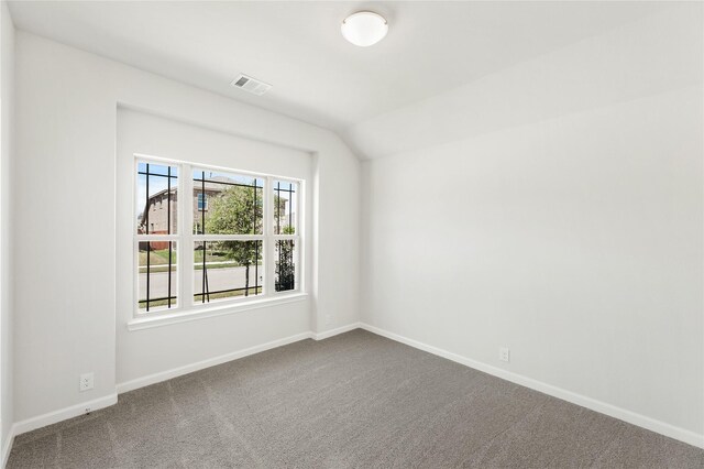 unfurnished room featuring lofted ceiling and carpet