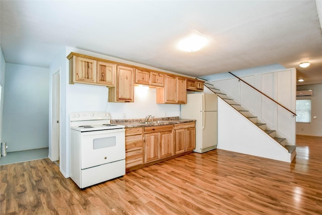 kitchen featuring a wall unit AC, sink, light hardwood / wood-style floors, and white appliances