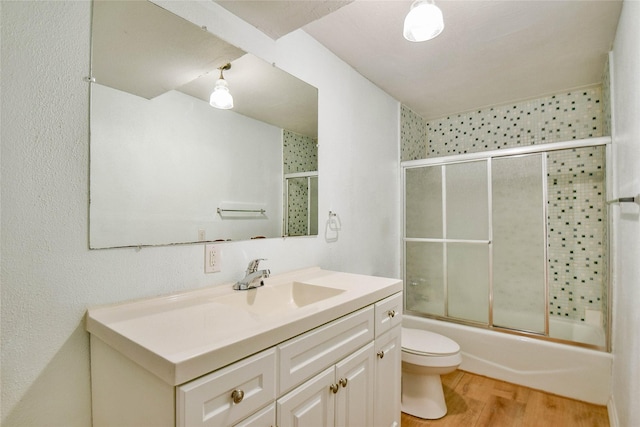 full bathroom featuring vanity, hardwood / wood-style flooring, toilet, and enclosed tub / shower combo