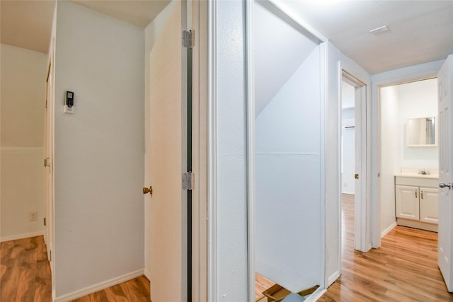 hallway featuring light hardwood / wood-style flooring and sink