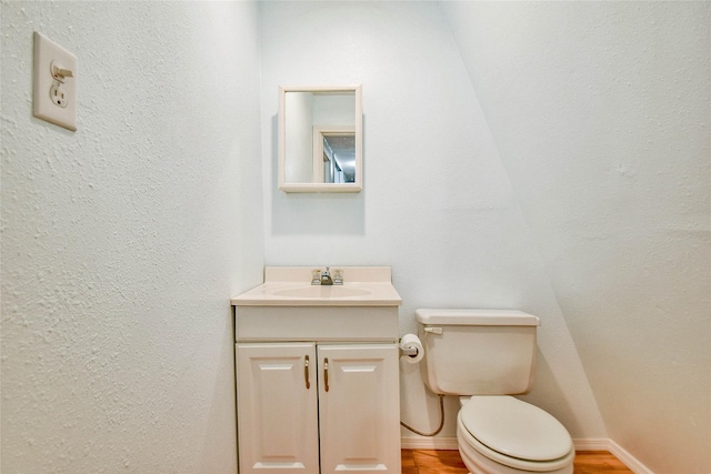 bathroom featuring hardwood / wood-style flooring, vanity, and toilet