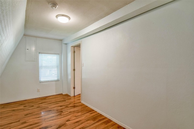 bonus room featuring light wood-type flooring and electric panel