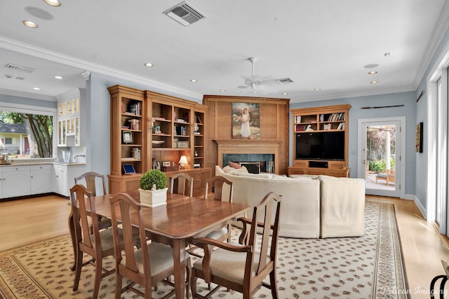 dining room featuring a wealth of natural light, light hardwood / wood-style flooring, and crown molding