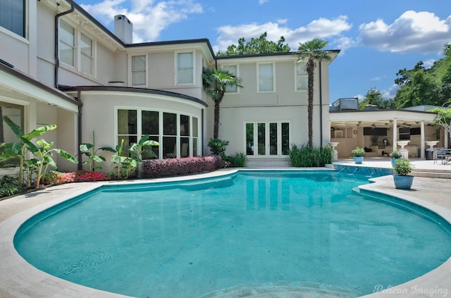 view of swimming pool with french doors and a patio