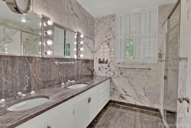 bathroom featuring an enclosed shower, double sink vanity, and tile walls