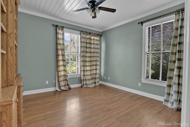 empty room with a healthy amount of sunlight, wood-type flooring, ceiling fan, and crown molding