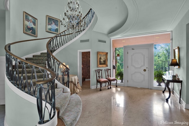 tiled entryway featuring a chandelier and a high ceiling