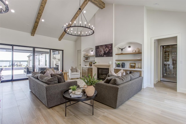 living room featuring an inviting chandelier, high vaulted ceiling, built in features, and light hardwood / wood-style flooring