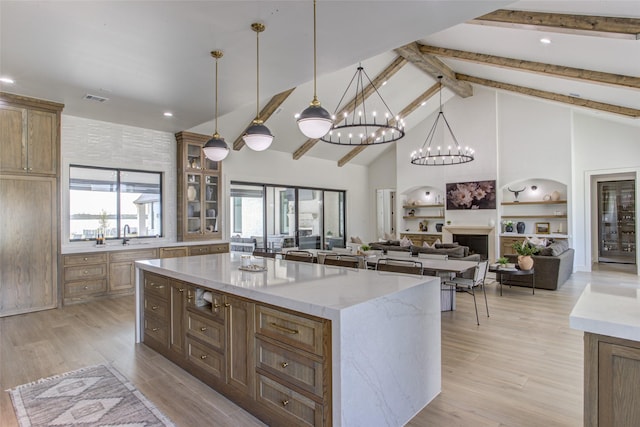 kitchen featuring a center island, light wood-type flooring, hanging light fixtures, and high vaulted ceiling