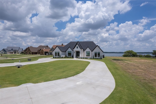 tudor home with a front yard and a water view