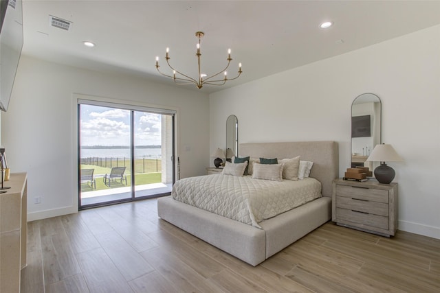 bedroom with access to exterior, a chandelier, and light hardwood / wood-style flooring