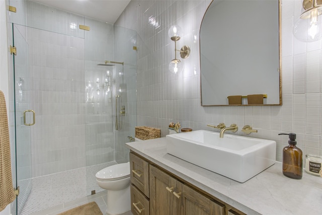 bathroom featuring tile patterned floors, an enclosed shower, vanity, tile walls, and toilet