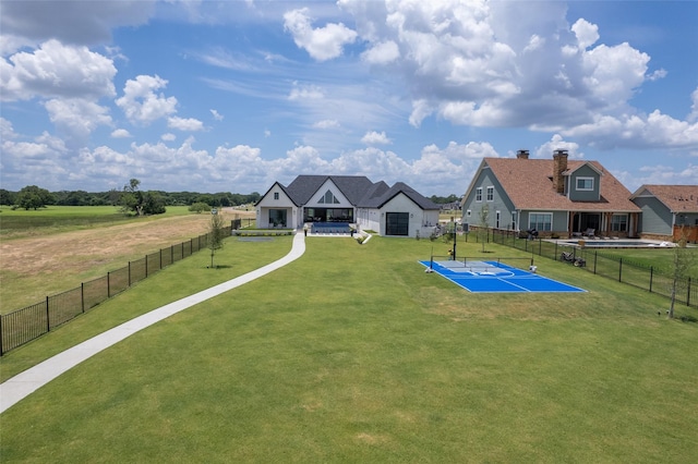 exterior space with tennis court and a lawn