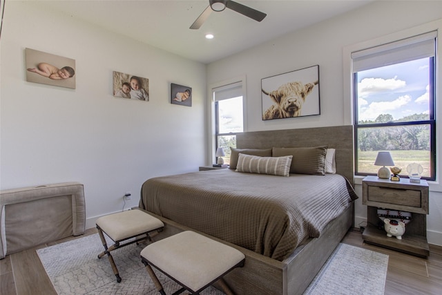 bedroom with ceiling fan and light hardwood / wood-style flooring