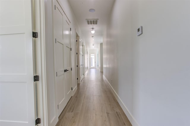 corridor with light hardwood / wood-style floors