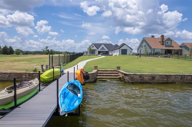 dock area with a lawn and a water view