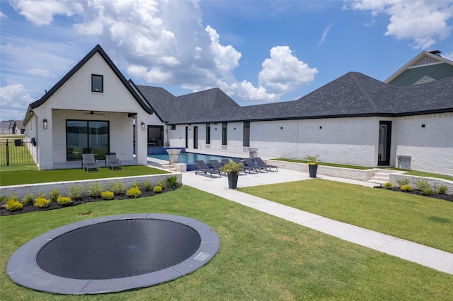 exterior space with a fenced in pool, a patio area, ceiling fan, and a lawn