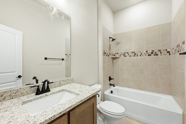 full bathroom featuring tiled shower / bath, vanity, and toilet