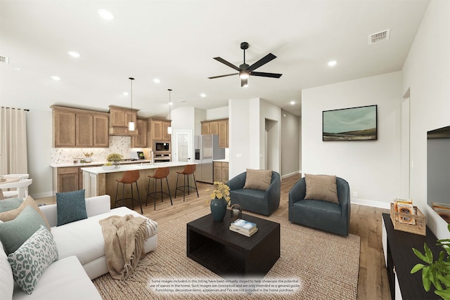 living room with sink, light wood-type flooring, and ceiling fan