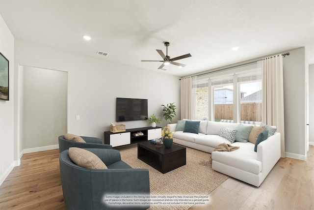 living room featuring light wood-type flooring and ceiling fan