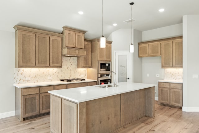 kitchen featuring sink, light wood-type flooring, lofted ceiling, pendant lighting, and a center island with sink