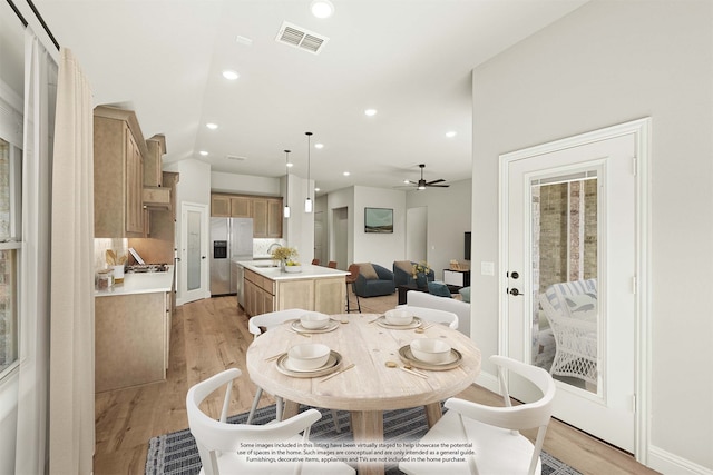 dining room featuring light hardwood / wood-style flooring, sink, and ceiling fan