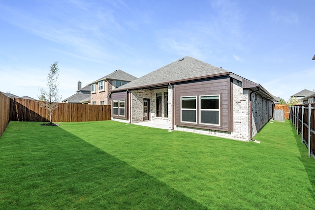 rear view of property featuring a patio and a lawn